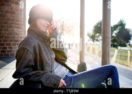 Portrait of woman wearing Knit hat sitting on steps park Banque D'Images