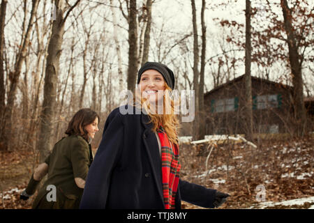 Happy friends marcher en forêt en hiver Banque D'Images