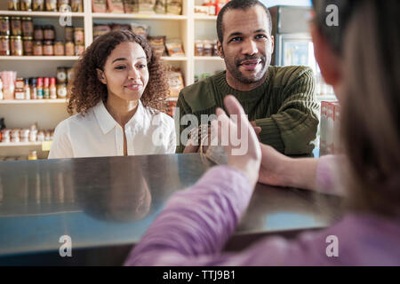 Les clients à la recherche de propriétaire alors que l'article en magasin Banque D'Images