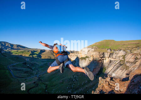 Vue arrière de l'homme base jumping from mountain Banque D'Images