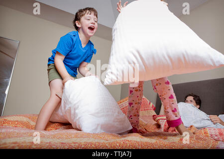 Low angle view of kids playing pillow fight Banque D'Images