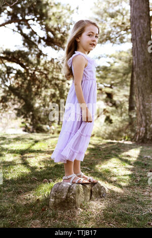 Happy Girl standing on rock in backyard Banque D'Images