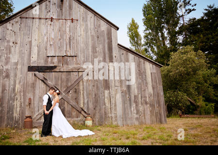 Young Woman standing on grassy field contre house Banque D'Images