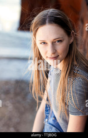 Portrait of woman leaning on wall Banque D'Images