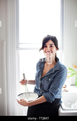 Portrait de femme préparant la crème fouettée à la maison Banque D'Images