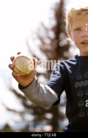 Close-up of boy holding baseball Banque D'Images