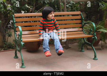 Girl sitting on a park bench Stock Photo