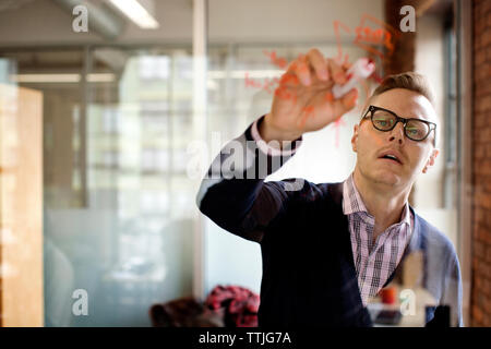 Plan d'un homme écrit sur verre in office Banque D'Images