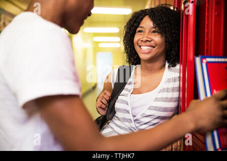 Femme souriante avec ami debout dans vestiaire Banque D'Images