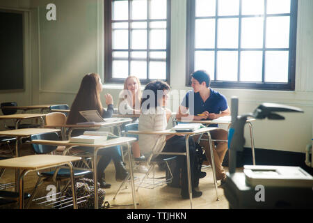 Friends sitting in classroom Banque D'Images