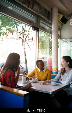 Amis parler alors qu'il était assis dans le café Banque D'Images