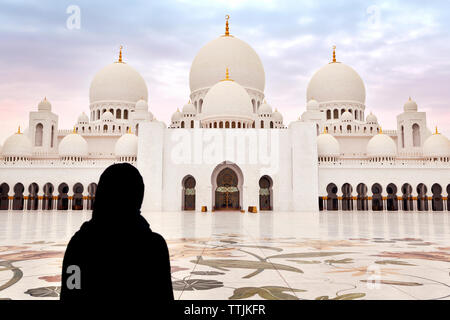 Vue arrière de femme debout contre la mosquée Sheikh Zayed Banque D'Images