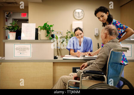 Les femmes médecins talking with senior patient in hospital Banque D'Images