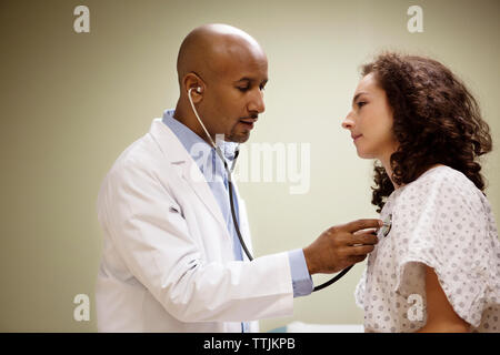 Vue latérale du doctor examining patient in hospital Banque D'Images