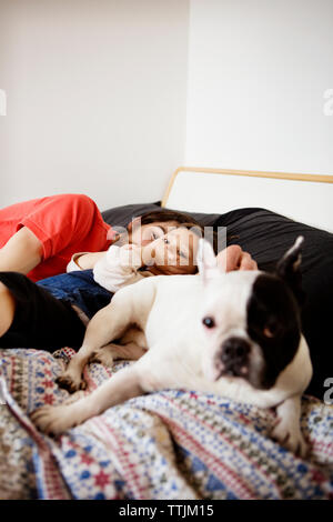 Portrait of man sleeping with daughter and dog on bed Banque D'Images