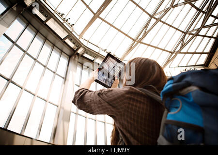 Low angle view of woman photographing plafond à railroad station Banque D'Images