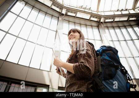 Low angle view of woman looking away while standing à railroad station Banque D'Images