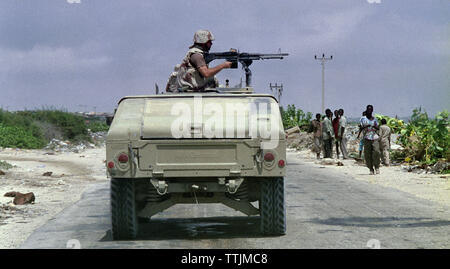 5 novembre 1993 Un soldat américain mans une mitrailleuse M60 au-dessus de sa tête comme il l'Humvee au nord, vers Mogadishu, Somalie. Banque D'Images