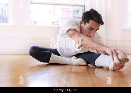 Professeur de ballet d'hommes déterminés exerçant sur le plancher au studio Banque D'Images