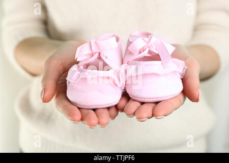 Woman holding baby booties, gros plan Banque D'Images