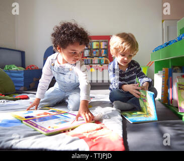 Les enfants avec des livres d'images en maternelle sur sunny day Banque D'Images