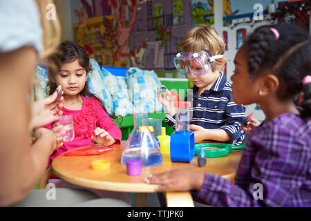 Les enfants faire de la science experiment at table in preschool Banque D'Images