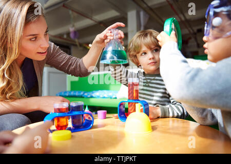 L'enseignant et les étudiants en science experiment at table in preschool Banque D'Images