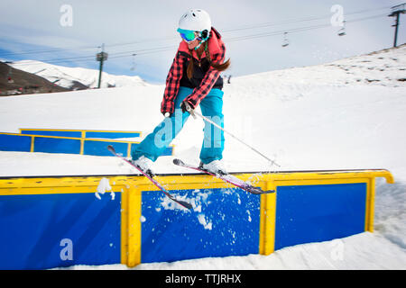 Woman performing stunt en skiant sur main courante Banque D'Images