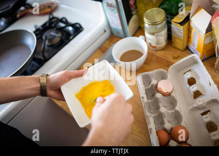 Portrait de l'homme battre les oeufs dans la cuisine Banque D'Images
