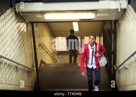 Toute la longueur du port de l'uniforme scolaire des élèves à l'étage à pied de la station de métro Banque D'Images