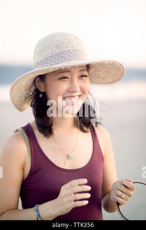 Happy woman looking away while standing at beach Banque D'Images