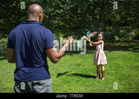 Heureux père et fille jouant avec kite on grassy field Banque D'Images Heureux père et fille jouant avec kite on grassy field Banque D'Images