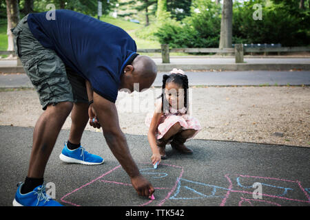 Père et fille de marelle dessin sur route à park Banque D'Images