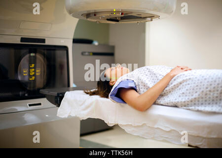 Female patient lying sous machine à rayons x à l'hôpital Banque D'Images