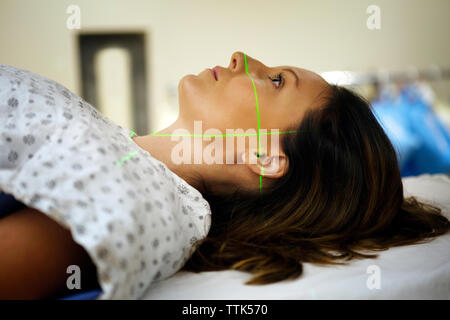 Vue latérale du woman lying on table d'examen à l'hôpital Banque D'Images