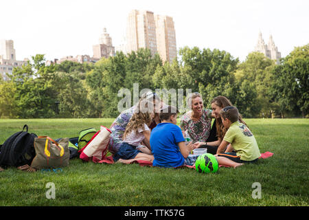 La famille et les amis profiter de pique-nique au parc en ville Banque D'Images