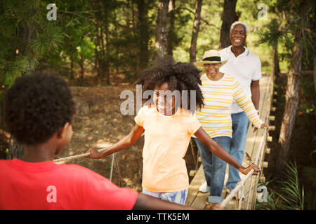 Happy Family walking on footbridge in forest Banque D'Images