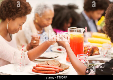 Family en priant à table de petit déjeuner Banque D'Images