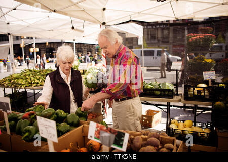 L'achat en couple des légumes au marché de rue Banque D'Images