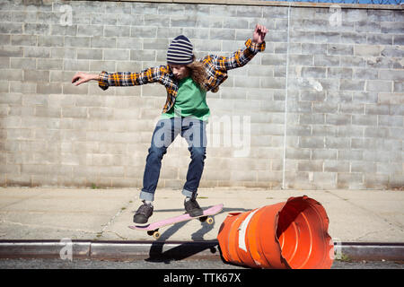 Man performing skateboard stunt sur le baril le street Banque D'Images