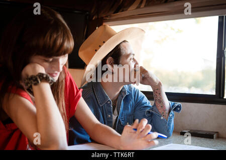 Thoughtful man sitting with woman en voyageant dans le camping-car Banque D'Images
