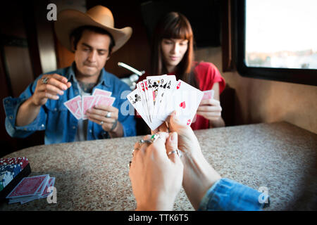 Close-up of woman holding cartes tout en jouant avec des amis dans le camping-car Banque D'Images