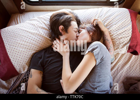 Couple en position allongée sur lit dans le camping-car Banque D'Images