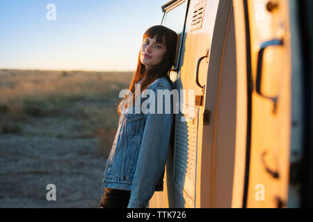 Portrait of woman leaning on camper van Banque D'Images
