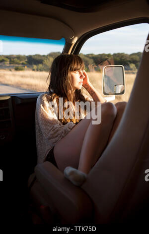 Thoughtful woman looking out of window while sitting in camper van Banque D'Images