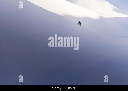 Femme grimper sur skis nordiques en sommet Skypilot Banque D'Images