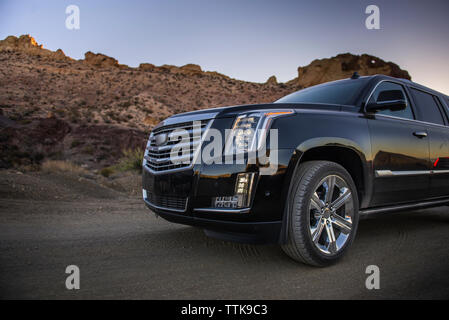 Voiture de luxe sur la route de terre s'est arrêté près de montagnes en désert, Close up Banque D'Images