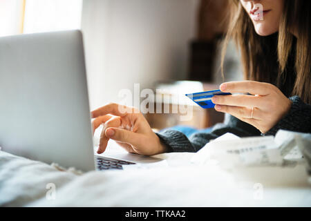 Portrait of woman shopping online with credit card at home Banque D'Images