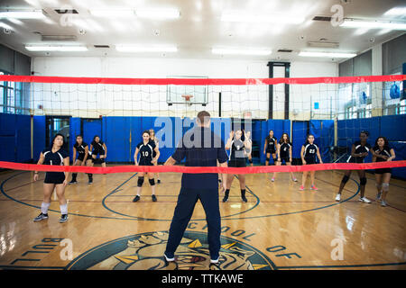 Entraîneur masculin de l'exercice d'enseignement à l'équipe de volley-ball féminin Banque D'Images