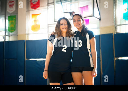 Portrait of smiling teenage girls standing en volley-ball Banque D'Images